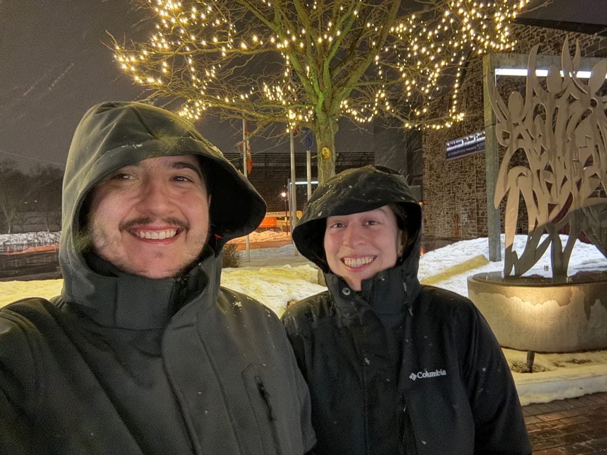 Mercedes and Michael in the snow under a tree strung with lights